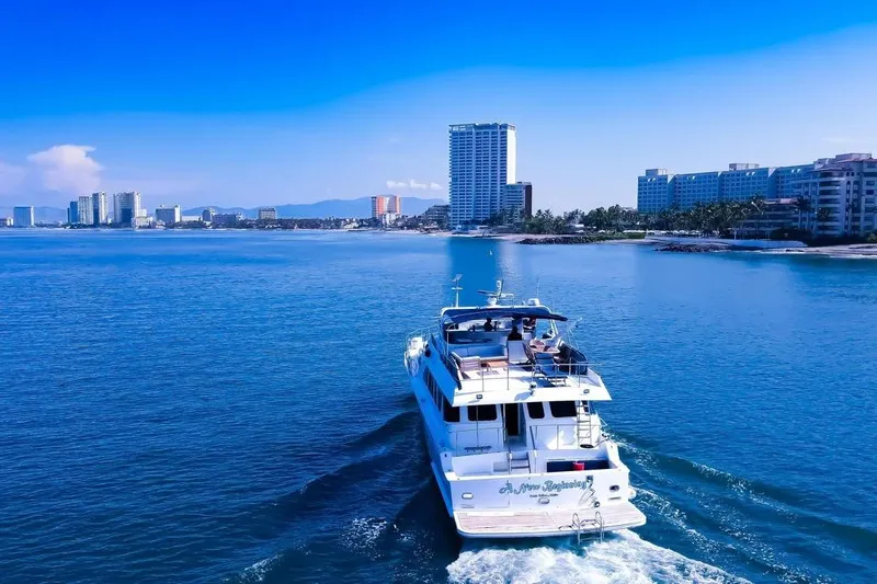 New Beginning Yacht Photos Pics Cheoy Lee 75 yacht cruising near coastal cityscape, clear blue sky, 1990 model.