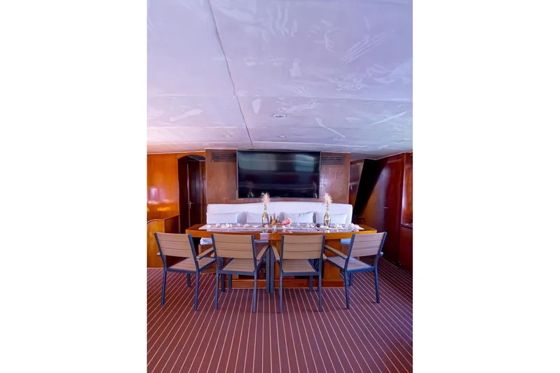 New Beginning Yacht Photos Pics Dining area on 1990 Cheoy Lee 75 yacht with elegant table setting and modern decor.