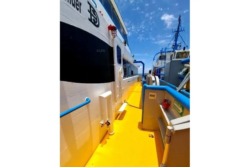  Yacht Photos Pics Bright yellow deck of a custom 2008 boat under clear blue sky.