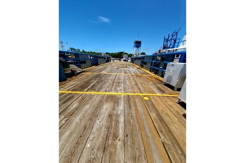  Yacht Photos Pics Wooden deck of a custom 2008 vessel under clear blue sky.