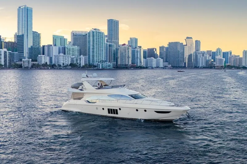 Drakkar Yacht Photos Pics Luxury 2012 Azimut Evolution yacht cruising near a city skyline at sunset.