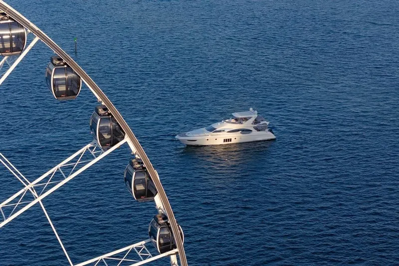Drakkar Yacht Photos Pics Luxurious 2012 Azimut Evolution yacht cruising near a Ferris wheel on the ocean.
