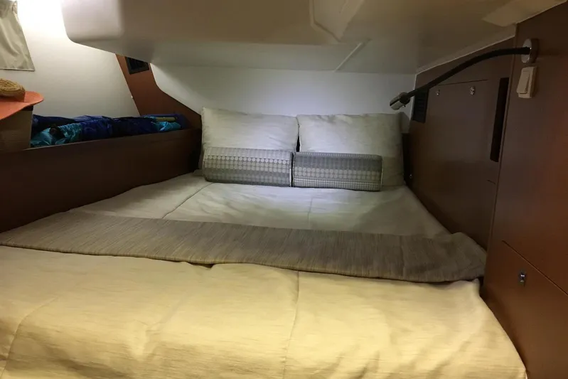 Portofolio Yacht Photos Pics Cozy cabin bed in 2013 Beneteau Oceanis 45 sailboat, featuring comfortable bedding and wooden interior.