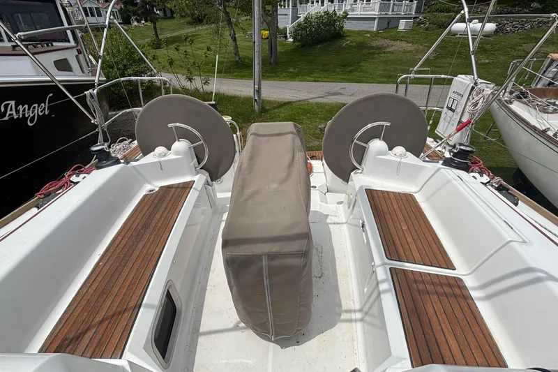 Statira Yacht Photos Pics 2017 Jeanneau Sun Odyssey 389 cockpit with wooden seating and covered steering wheel.