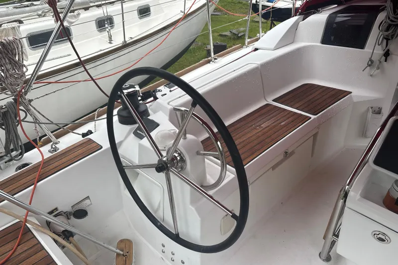 Statira Yacht Photos Pics 2017 Jeanneau Sun Odyssey 389 cockpit with steering wheel and wooden seating.