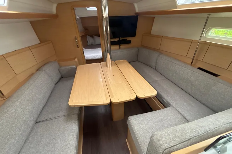 Statira Yacht Photos Pics Interior of 2017 Jeanneau Sun Odyssey 389 sailboat with cozy seating and wooden table.