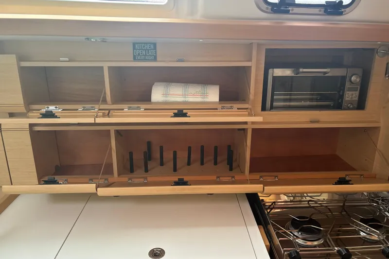 Statira Yacht Photos Pics Interior of 2017 Jeanneau Sun Odyssey 389 yacht kitchen with wooden cabinets and appliances.