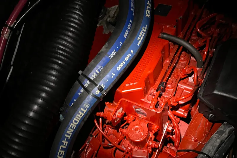 Sea Escape Yacht Photos Pics Engine compartment of a 2003 Beneteau 393 sailboat, featuring red components and Trident-Flex hose.