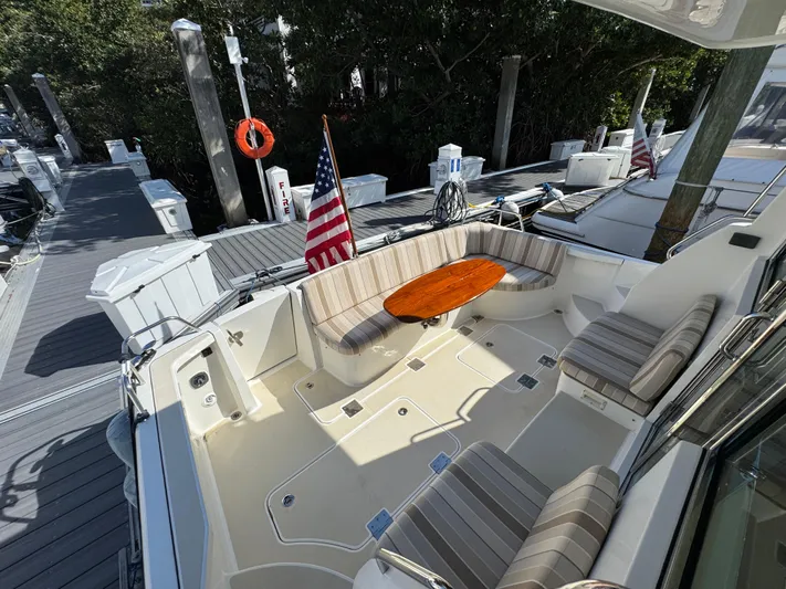  Yacht Photos Pics 2019 Sabre 42 Salon Express yacht with outdoor seating and American flag at dock.