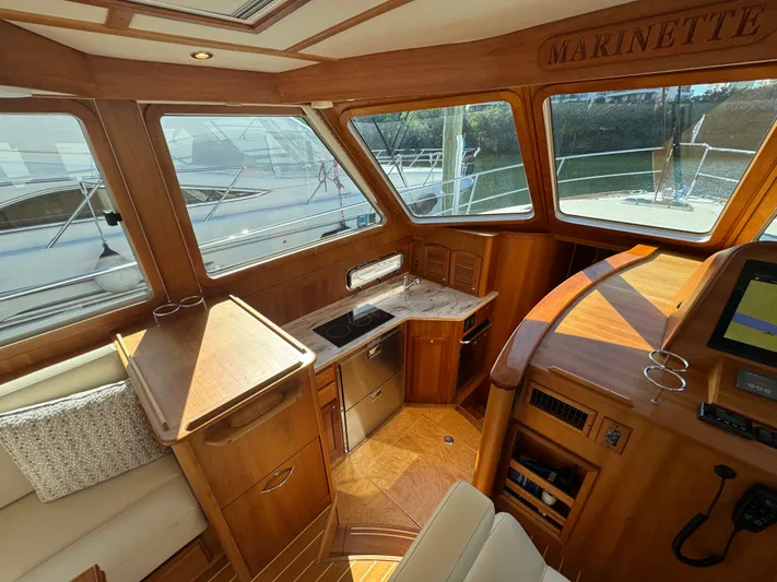  Yacht Photos Pics Interior of 2019 Sabre 42 Salon Express yacht with wooden cabinetry and large windows.