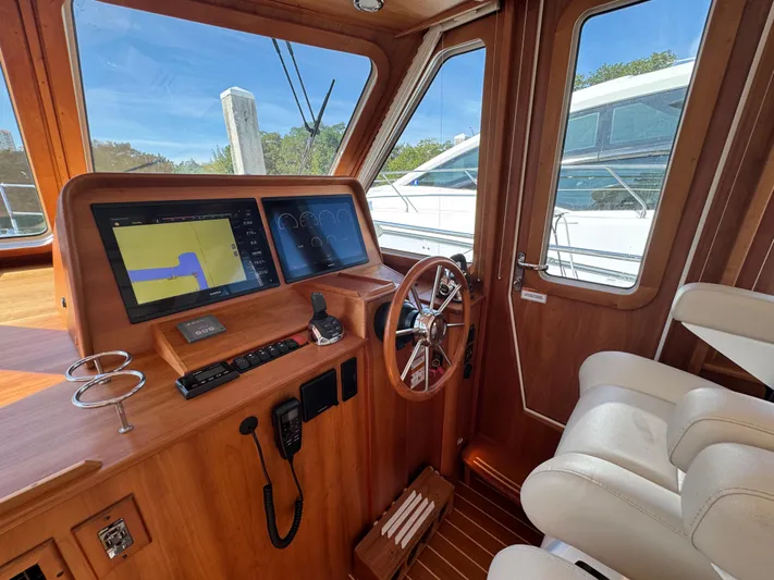  Yacht Photos Pics 2019 Sabre 42 Salon Express helm with navigation screens and wooden steering wheel.