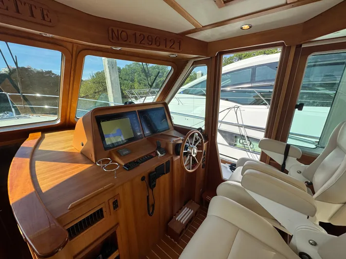  Yacht Photos Pics Interior of 2019 Sabre 42 Salon Express yacht with helm, navigation screens, and white seating.
