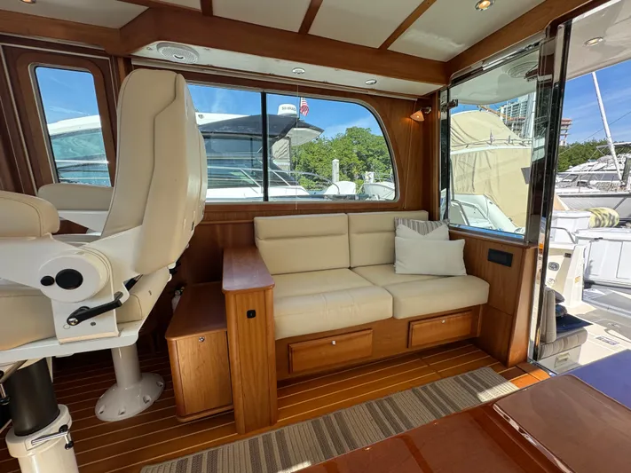  Yacht Photos Pics 2019 Sabre 42 Salon Express interior with cream sofa, wooden accents, and large windows.
