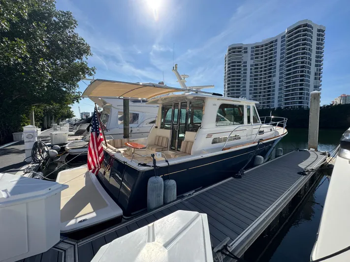  Yacht Photos Pics 2019 Sabre 42 Salon Express docked, featuring sleek design and American flag, with cityscape backdrop.