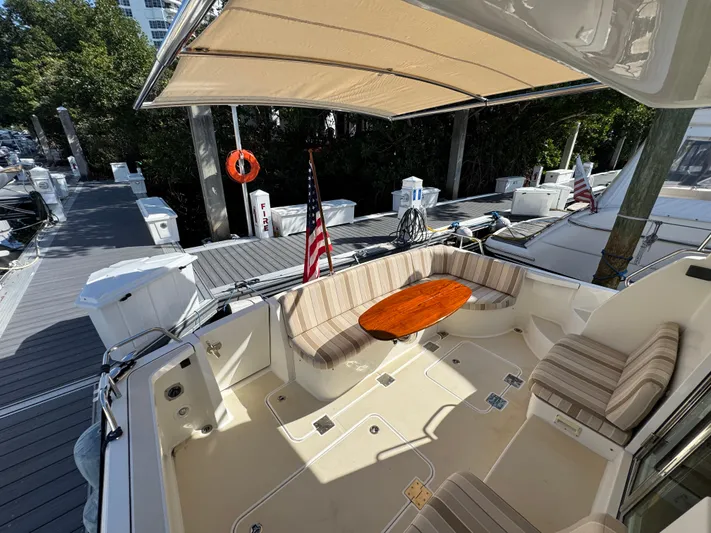  Yacht Photos Pics 2019 Sabre 42 Salon Express yacht with spacious deck, seating, and American flag at marina.