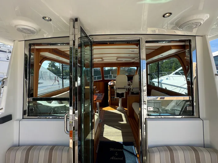  Yacht Photos Pics 2019 Sabre 42 Salon Express interior with glass doors, luxurious seating, and wooden accents.