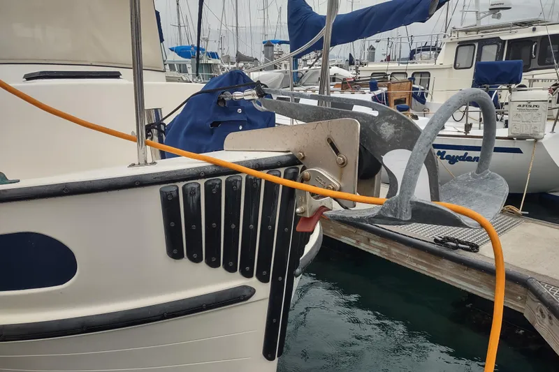 Dobro Yacht Photos Pics 1990 Nordic Tug 32 docked, featuring anchor and mooring lines in a marina setting.