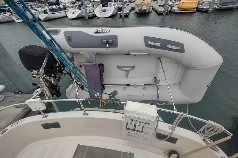 Dobro Yacht Photos Pics Nordic Tug 32 (1990) with dinghy and motor at marina dock.