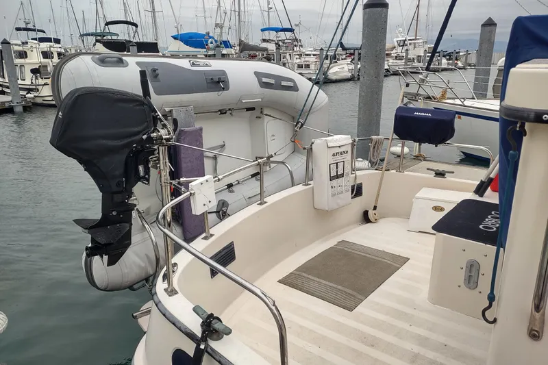 Dobro Yacht Photos Pics 1990 Nordic Tug 32 with dinghy and outboard motor at marina dock.