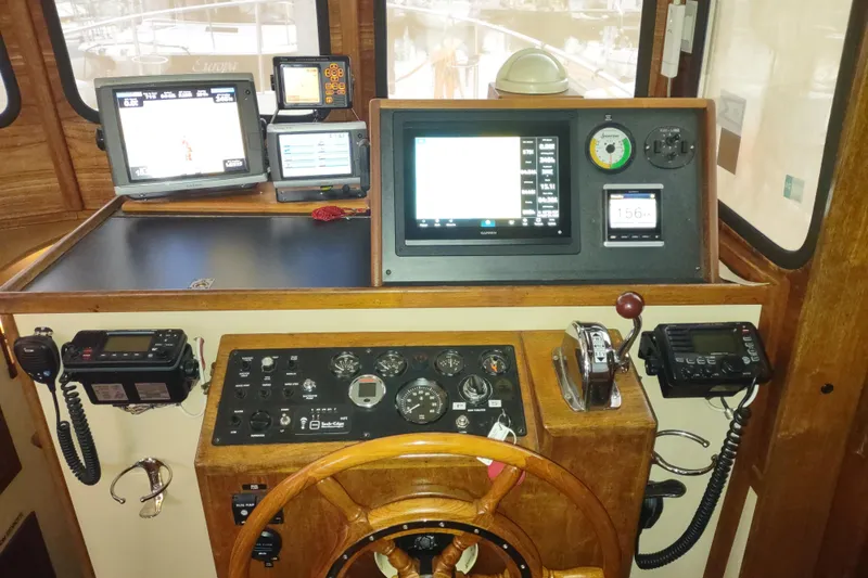 Dobro Yacht Photos Pics 1990 Nordic Tug 32 helm with navigation equipment and wooden steering wheel.