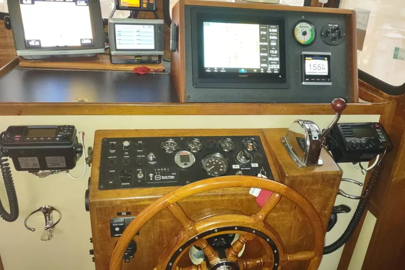 Dobro Yacht Photos Pics 1990 Nordic Tug 32 helm with navigation equipment and wooden steering wheel.