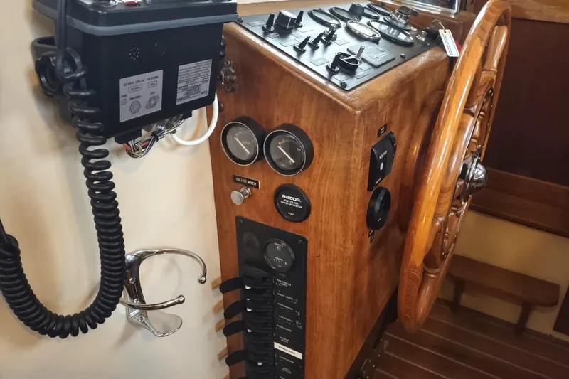 Dobro Yacht Photos Pics 1990 Nordic Tug 32 helm with wooden wheel, gauges, and control panel.