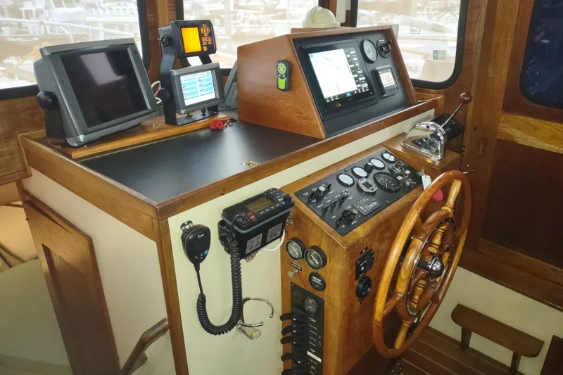 Dobro Yacht Photos Pics 1990 Nordic Tug 32 helm with navigation equipment and wooden steering wheel.