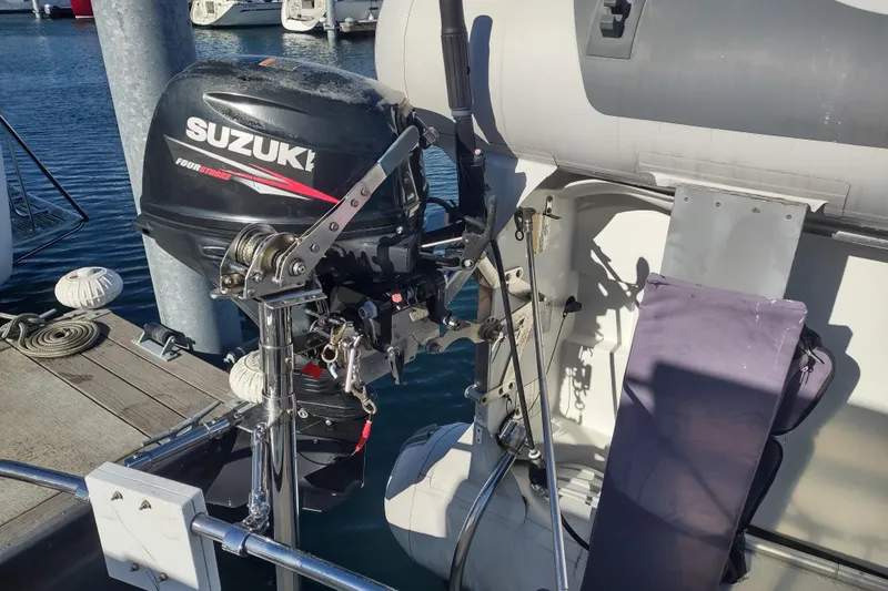 Dobro Yacht Photos Pics Suzuki outboard motor on a 1990 Nordic Tug 32, docked at a marina.