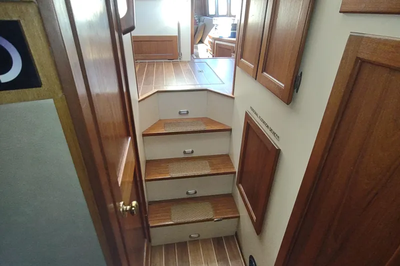 Dobro Yacht Photos Pics Interior stairs of a 1990 Nordic Tug 32 with wooden finish.