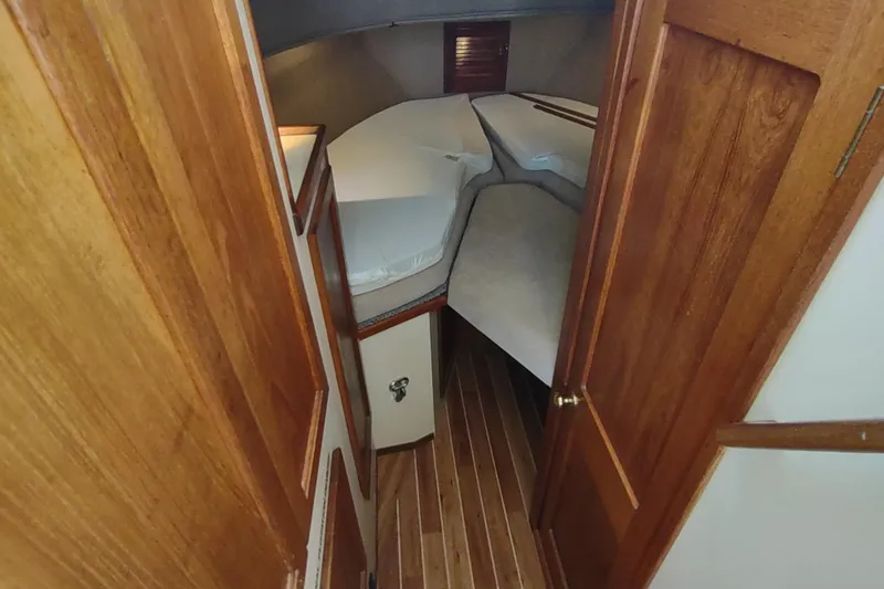 Dobro Yacht Photos Pics 1990 Nordic Tug 32 interior cabin with wooden finish and cozy sleeping area.