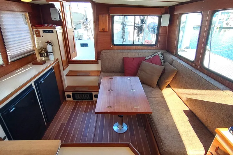 Dobro Yacht Photos Pics Cozy interior of a 1990 Nordic Tug 32 with wood accents and seating area.