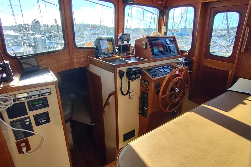 Dobro Yacht Photos Pics Interior of a 1990 Nordic Tug 32, featuring a classic wooden helm and navigation equipment.