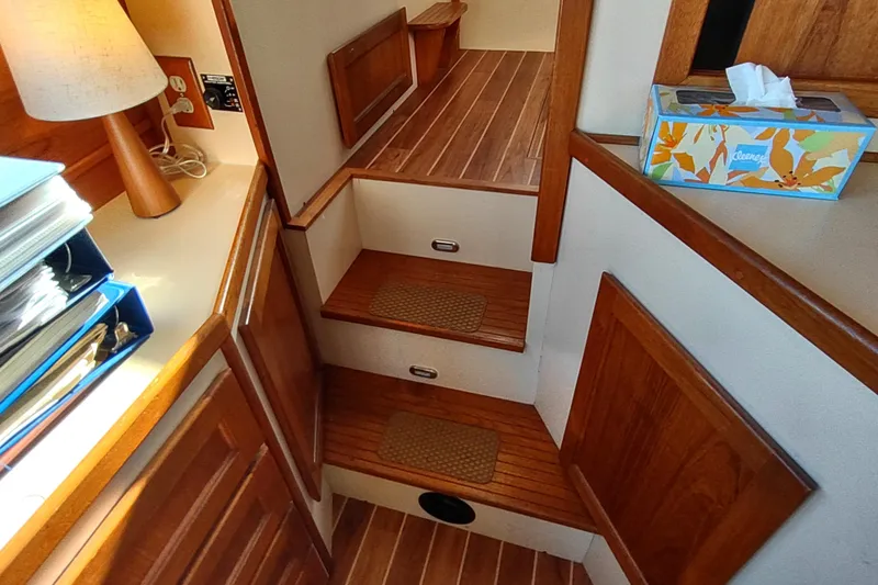 Dobro Yacht Photos Pics Interior of a 1990 Nordic Tug 32, featuring wooden steps and cozy decor.