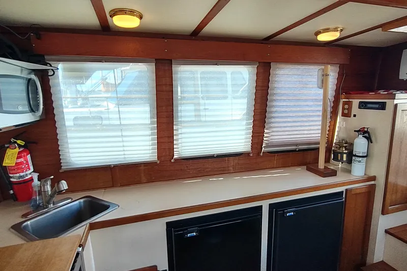 Dobro Yacht Photos Pics Interior of 1990 Nordic Tug 32 with kitchenette, windows, and safety equipment.