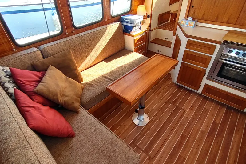 Dobro Yacht Photos Pics Cozy interior of a 1990 Nordic Tug 32 with wood accents and comfortable seating.