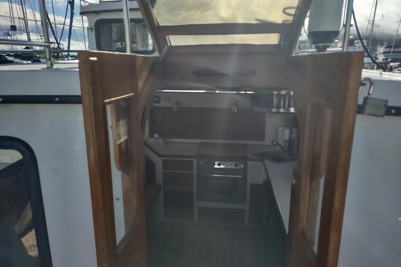 Dobro Yacht Photos Pics Interior view of a 1990 Nordic Tug 32, showcasing the compact kitchen area.