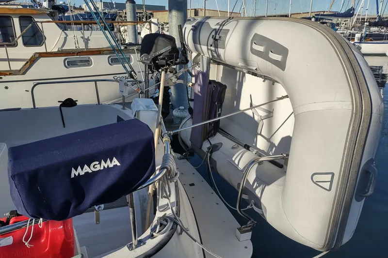 Dobro Yacht Photos Pics 1990 Nordic Tug 32 with inflatable dinghy and Magma grill in marina setting.