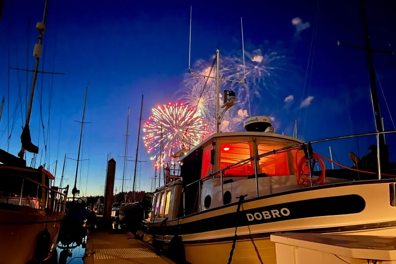 Dobro Yacht Photos Pics Nordic Tug 32 boat at marina with fireworks in the night sky, 1990 model.