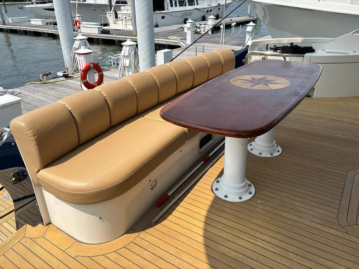 Bad Bettye Yacht Photos Pics Luxury yacht deck with tan seating and wooden table, Marquis 65, 2006 model.