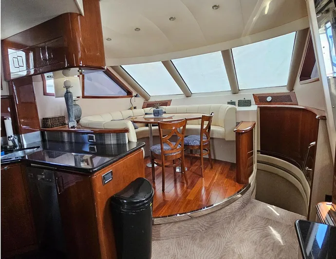 Bad Bettye Yacht Photos Pics Luxurious interior of a 2006 Marquis 65 yacht with elegant wood finishes and seating area.