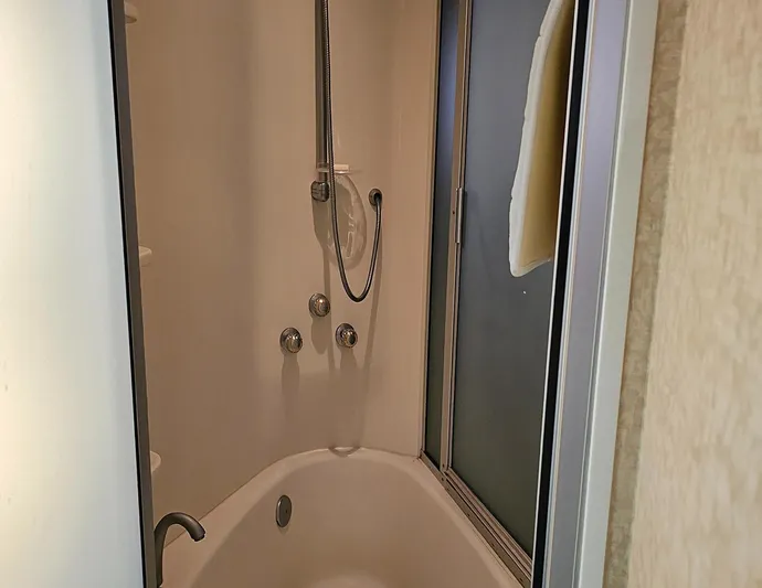 Bad Bettye Yacht Photos Pics Shower area in a 2006 Marquis 65 yacht, featuring a handheld showerhead and sliding door.