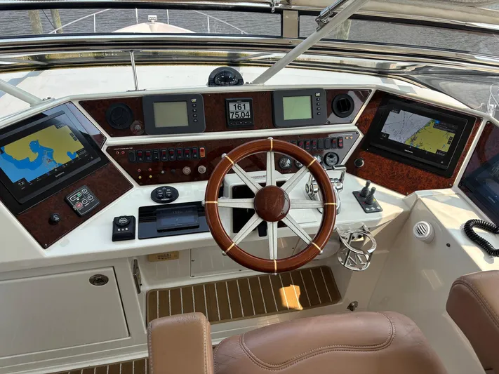 Bad Bettye Yacht Photos Pics Helm of 2006 Marquis 65 yacht with navigation screens and wooden steering wheel.