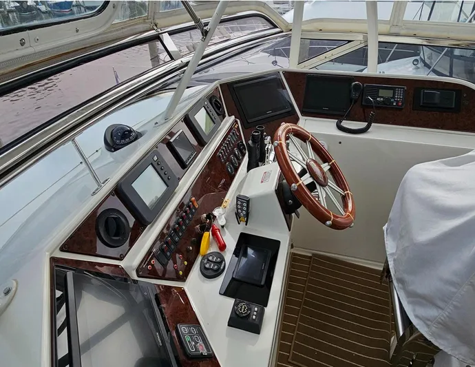 Bad Bettye Yacht Photos Pics Helm of 2006 Marquis 65 yacht with modern navigation equipment and wooden steering wheel.