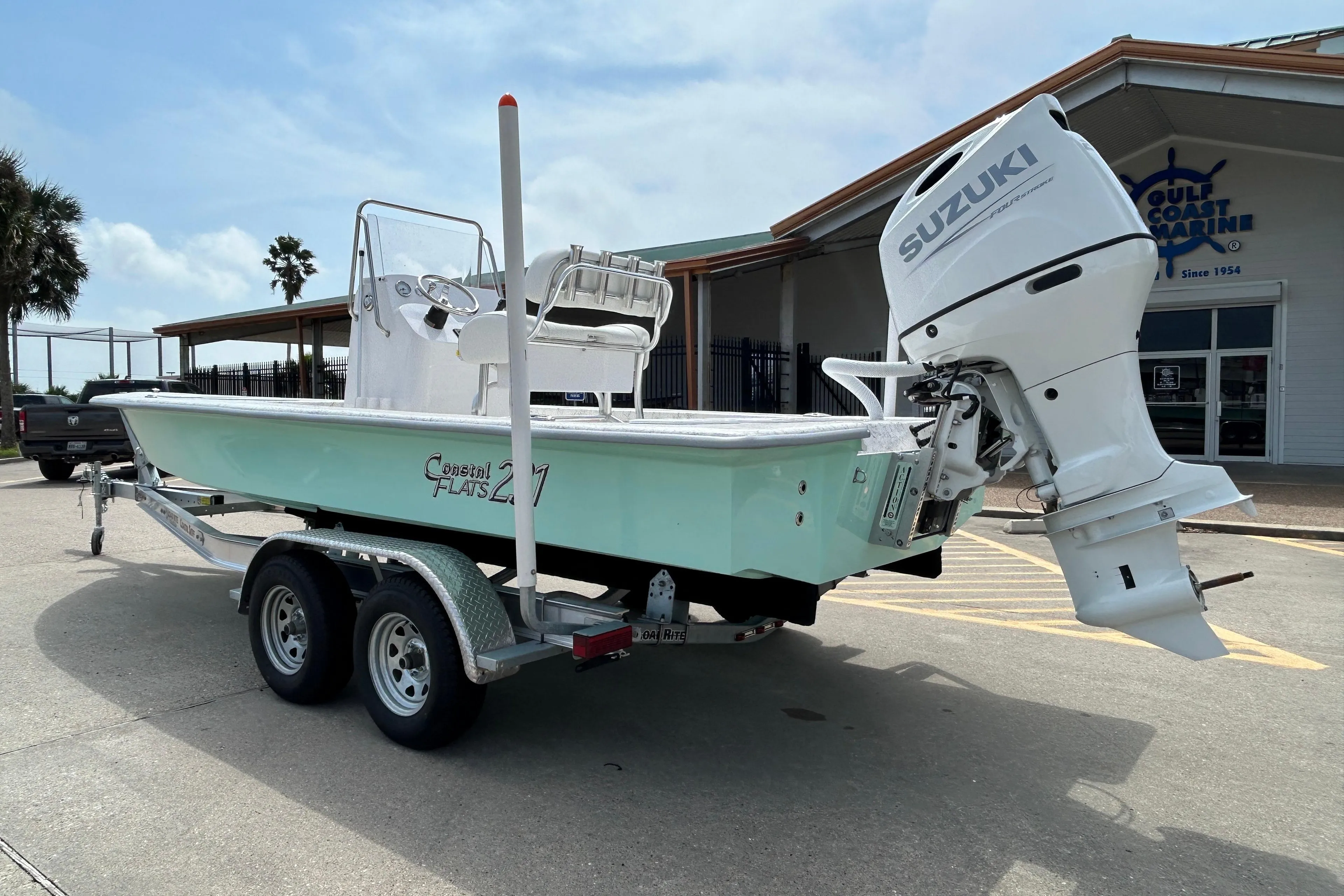 2026 Coastal Skiff 231 Flats boat with Suzuki outboard motor on trailer.