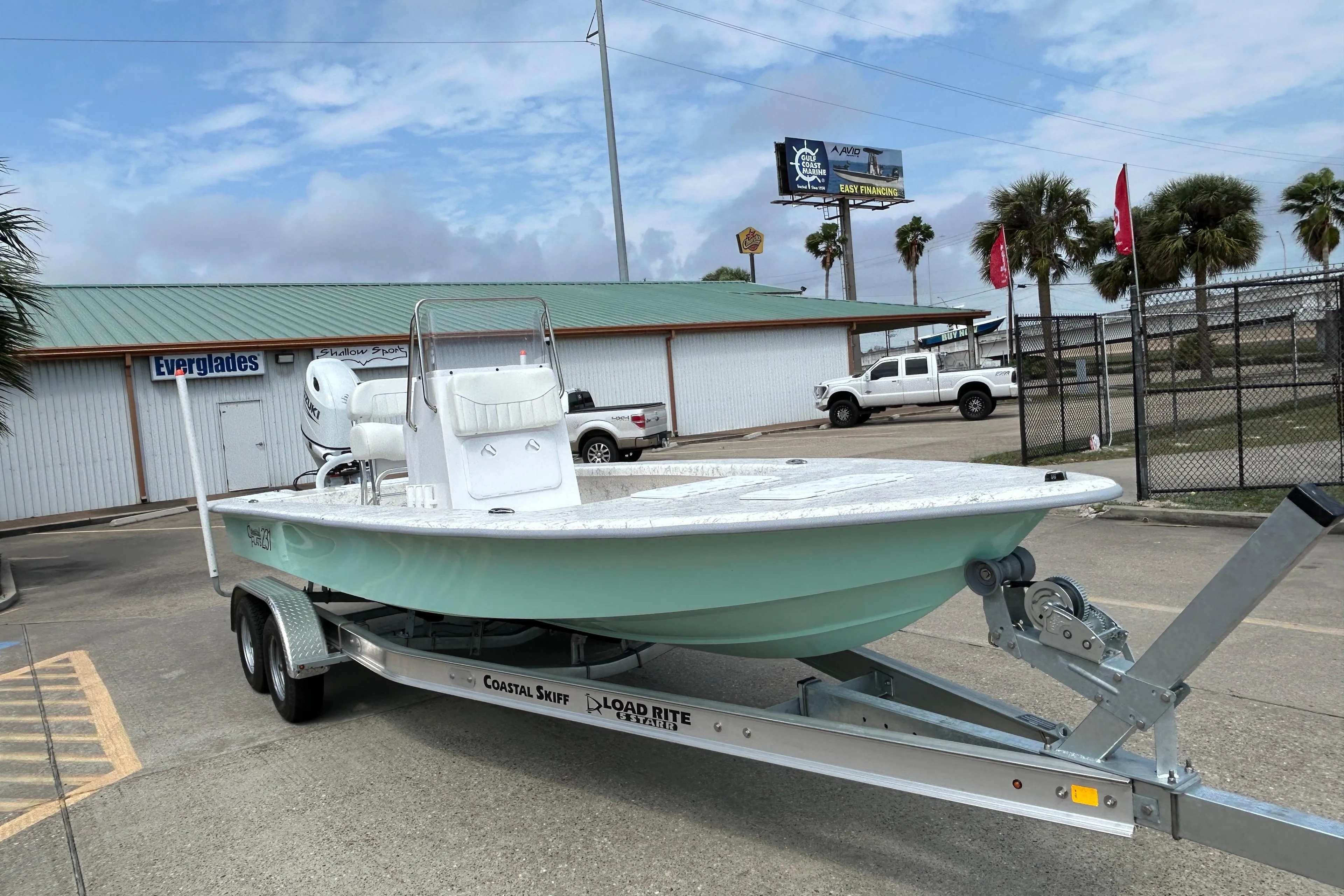 2026 Coastal Skiff 231 Flats boat on trailer, parked outdoors near dealership.