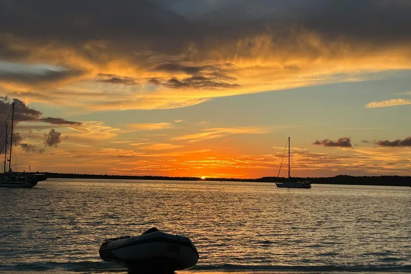 Simpatico Yacht Photos Pics Sunset over calm waters with sailboats, featuring a 1999 Catalina 42 MkII.