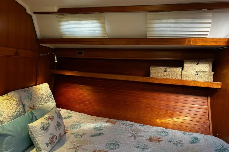 Simpatico Yacht Photos Pics Cozy cabin interior of 1999 Catalina 42 MkII sailboat with decorative bedding and storage baskets.