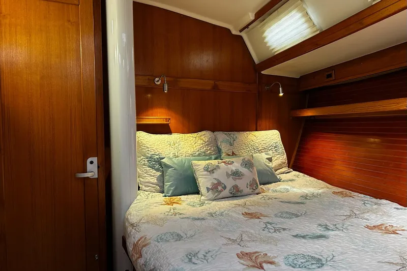 Simpatico Yacht Photos Pics Cozy cabin interior of 1999 Catalina 42 MkII sailboat with nautical-themed bedding.