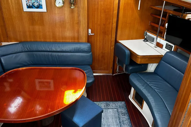 Simpatico Yacht Photos Pics Interior of a 1999 Catalina 42 MkII yacht with blue seating and wooden table.