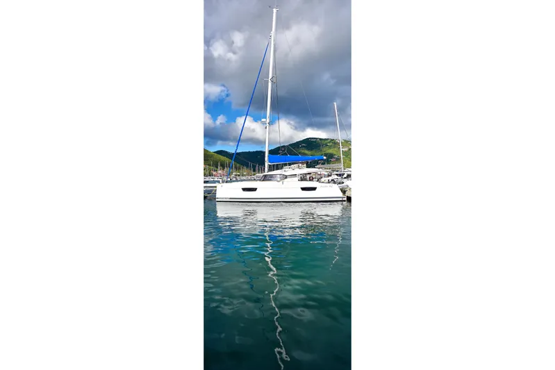 Boomerang Yacht Photos Pics 2022 Fountaine Pajot Astrea 42 catamaran docked in a scenic marina.